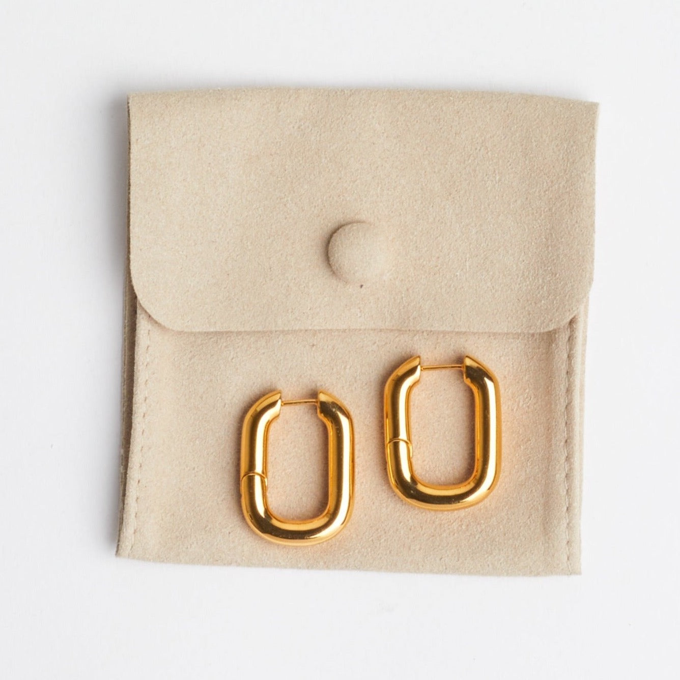 The Taryn | Gold Rectangular Hoop Earrings on tan suede jewelry bag