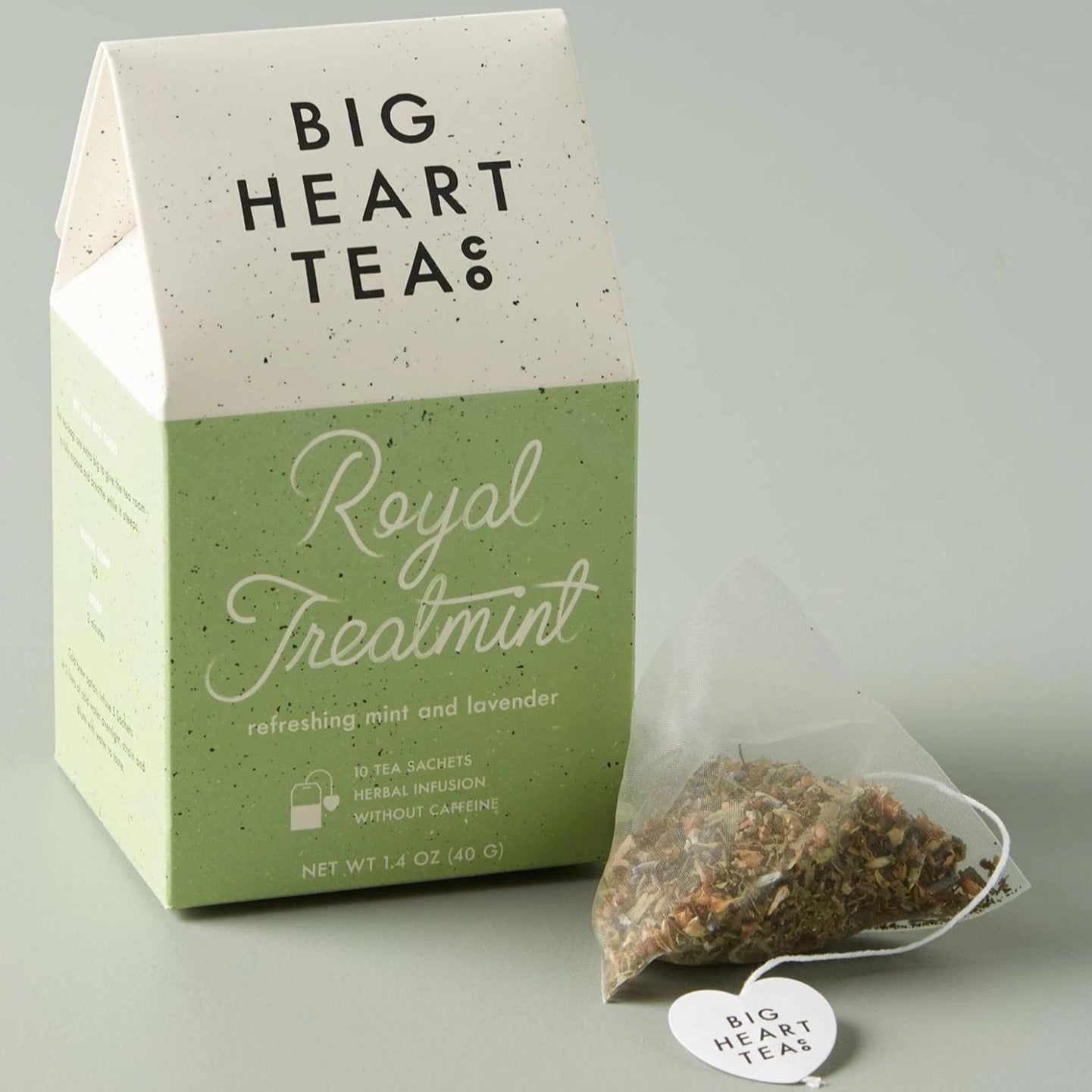 House-shaped tea box in green with a tea sachet outside and to the right of the box.