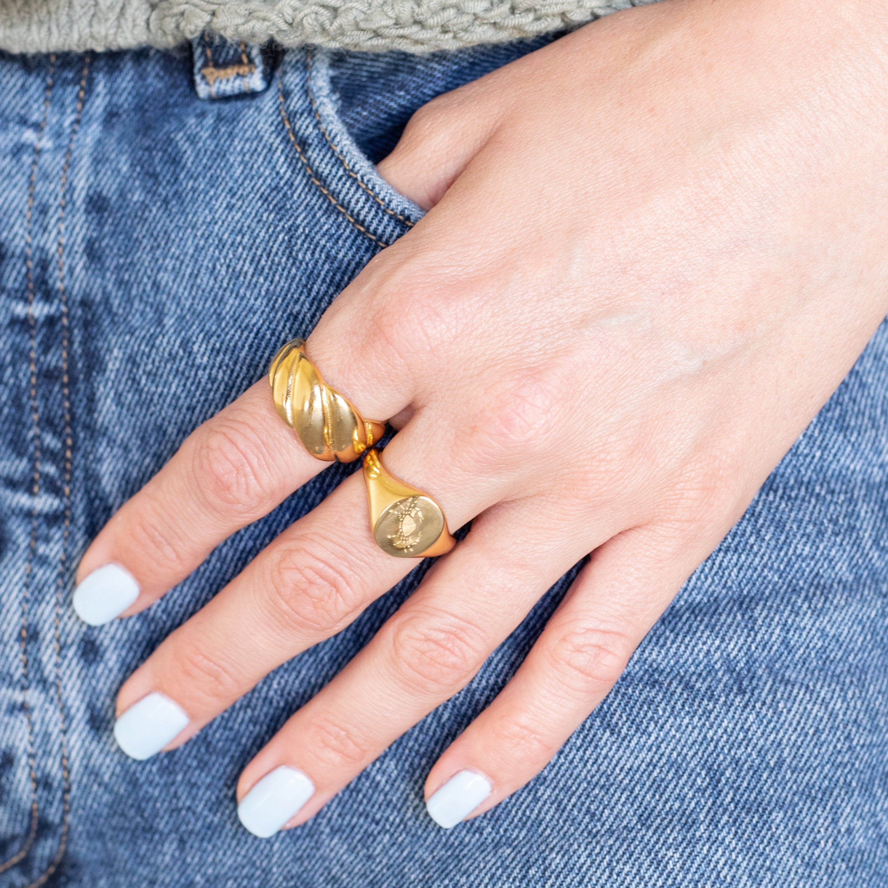 Hand with gold rings in pants pocket