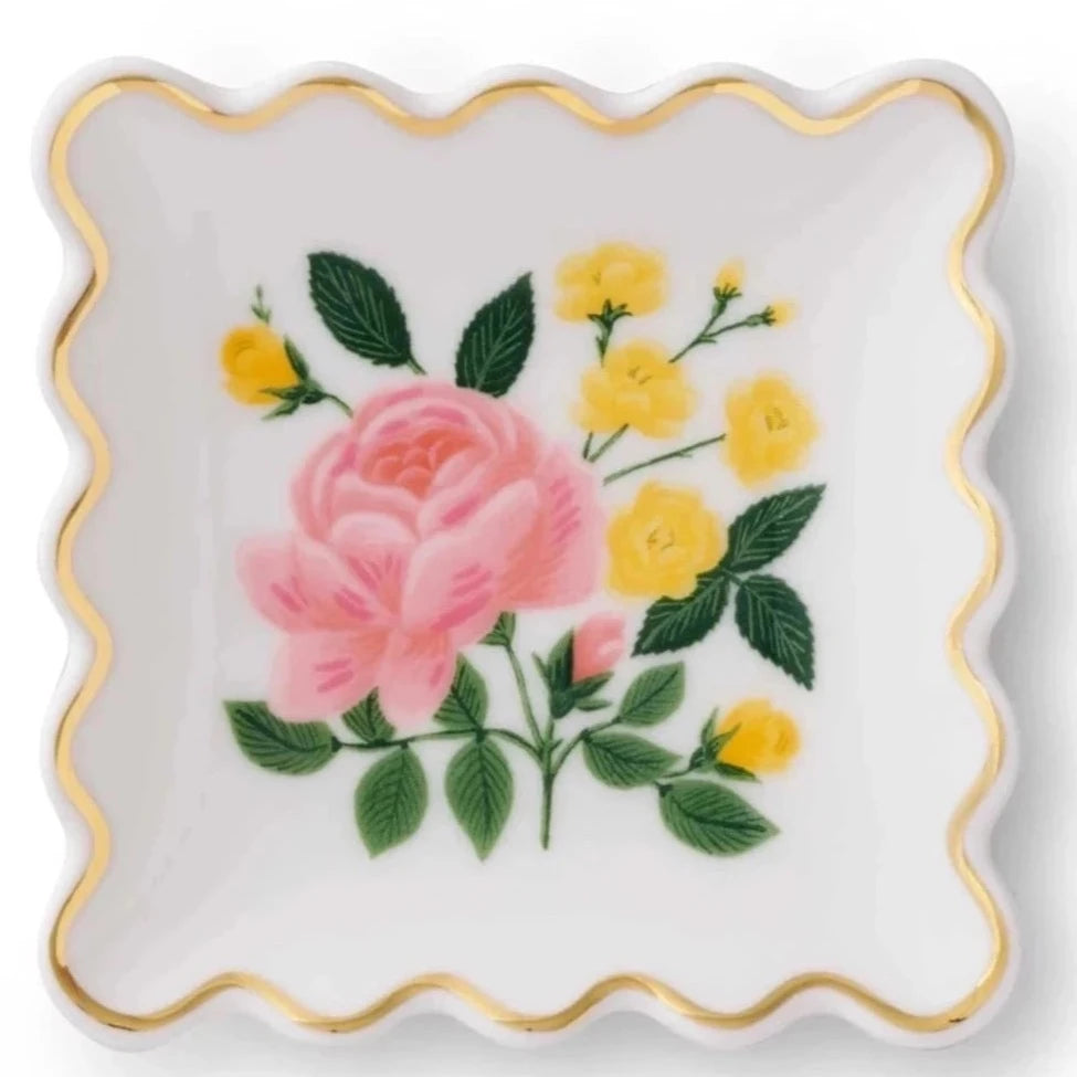 white rectangular ring dish with scalloped edges. in the center is a rose 