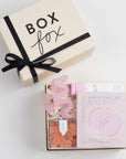 BOXFOX Bridesmaid Gift Box in Creme box with Sugarfina Sparkling Rosé Bears, Patchology Serve Chilled Rosé Eye Gels, Herbivore Dream Jelly Lip Balm, and NTBAB Pink Squiggle Hair Clip