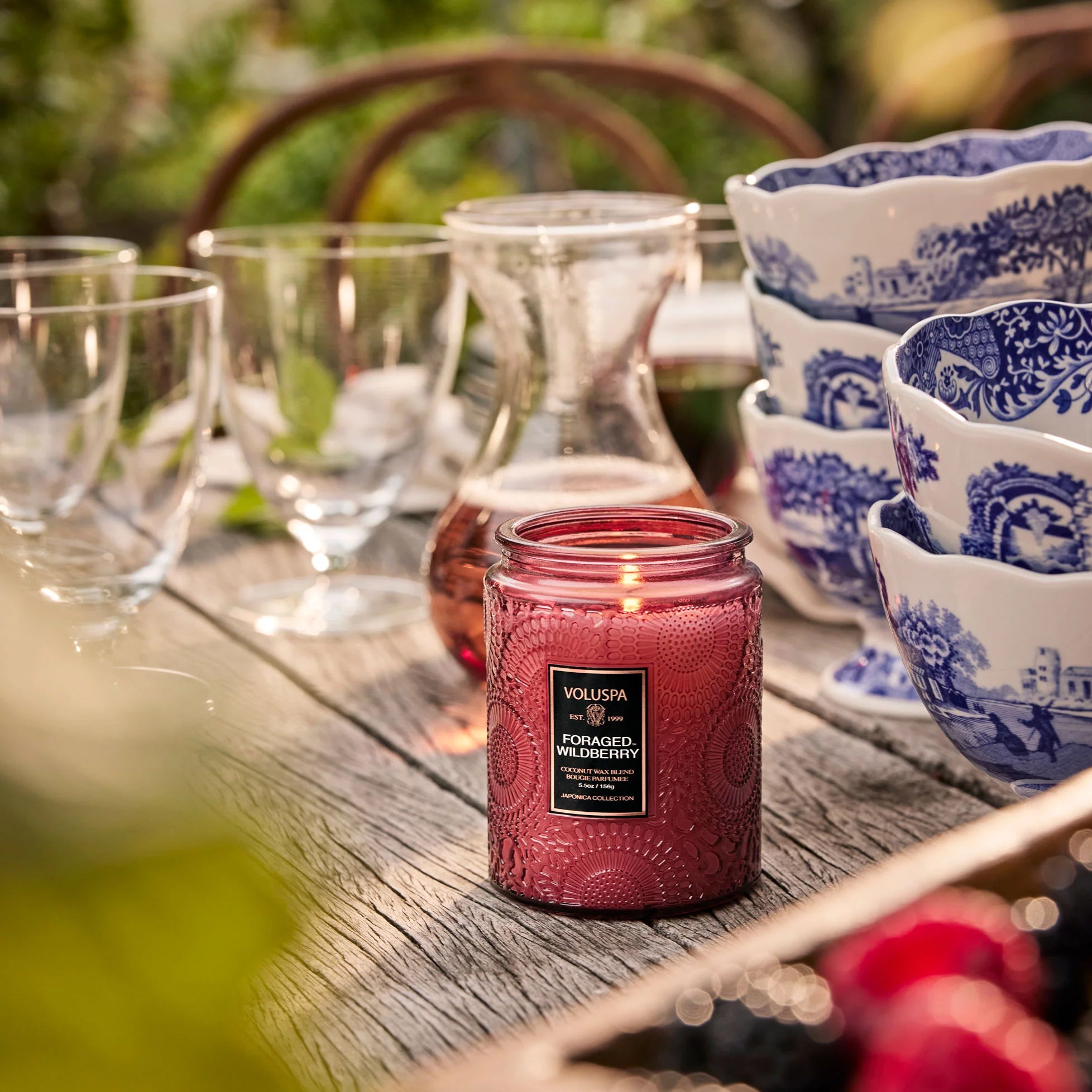 Foraged Wildberry candle on wooden table with glasses and ceramic bowls