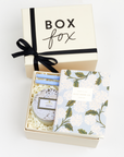 BOXFOX Original Creme Gift Box containing Rifle Paper Hydrangea Pocket Notebooks, 2 Periwinkle Le Pens, and Voluspa Mokara Petite Glass Jar Candle.