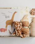 children's book, giraffe onesie, yellow hat, teether, baby lotion, and giraffe soother packed in a creme BOXFOX