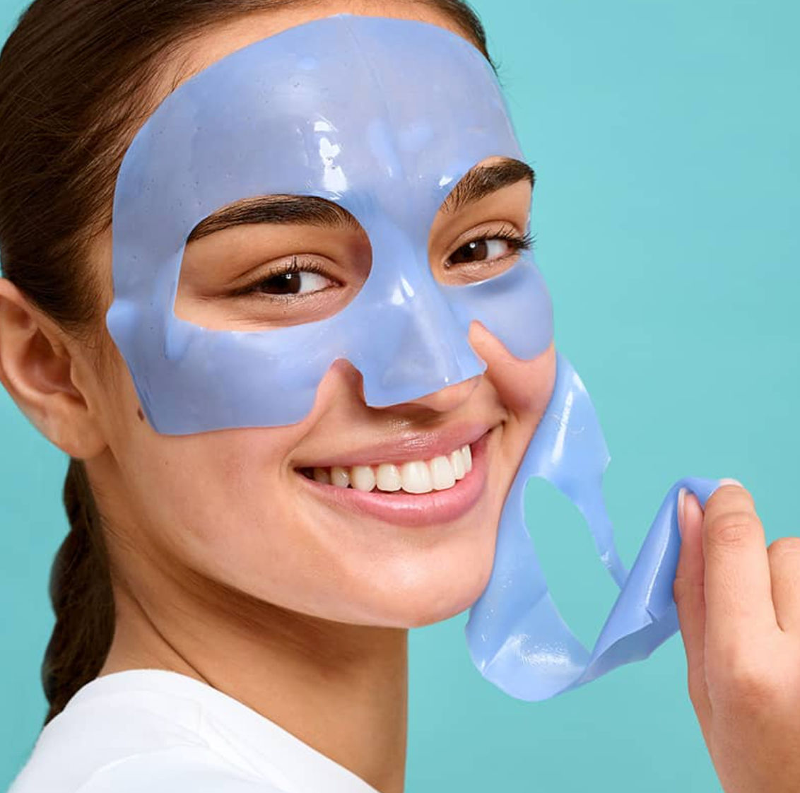 Girl peeling off face mask smiling