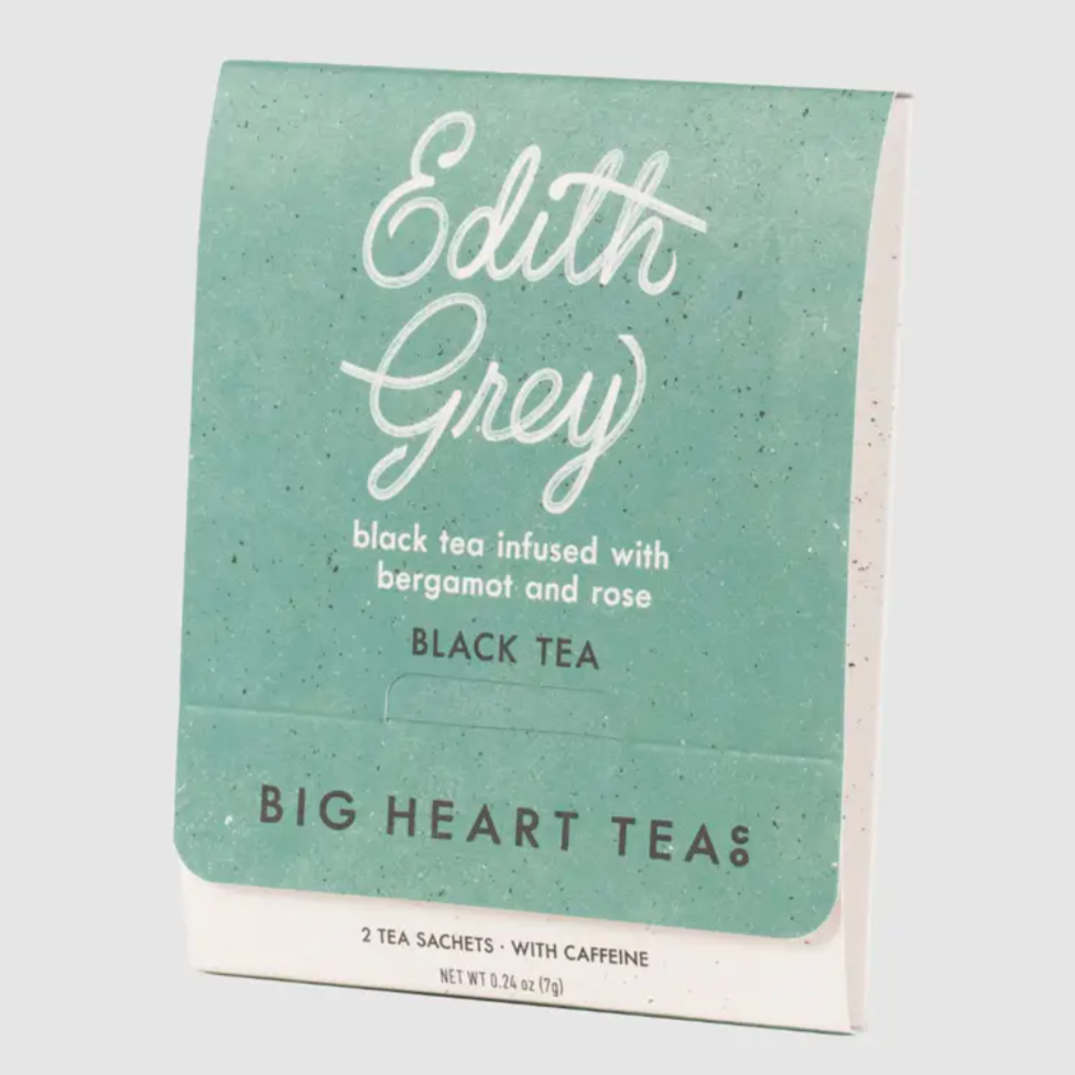 light green black tea sachet behind white background