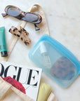 Small blue bag filled with hair essentials spilling out from tote bag.